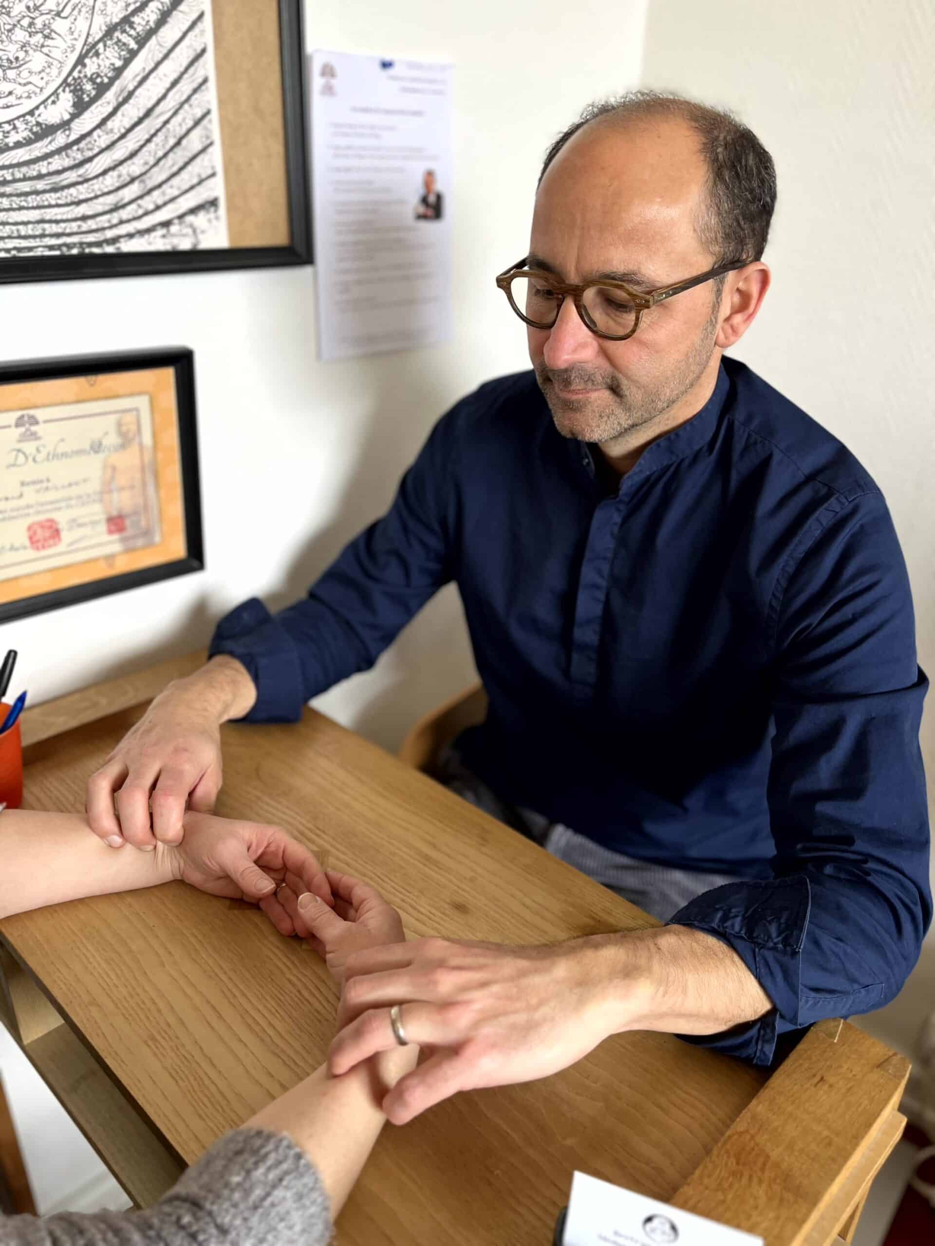 Bertrand Vaillant prenant le pouls d'une patiente, diagnostic de médecine traditionnelle chinoise